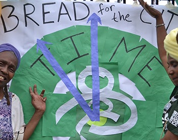 Two women pose with a poster for Bread for the City