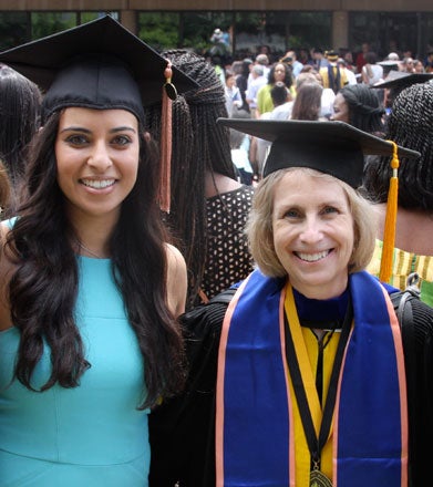 Marie Diener-West and M.D./MPH student Christina Marie Hanna, dressed in caps, smile for the camera.