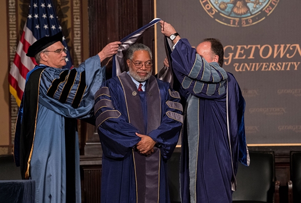 Provost Robert Groves and President John J. DeGioia hood Lonnie Bunch for his honorary doctorate