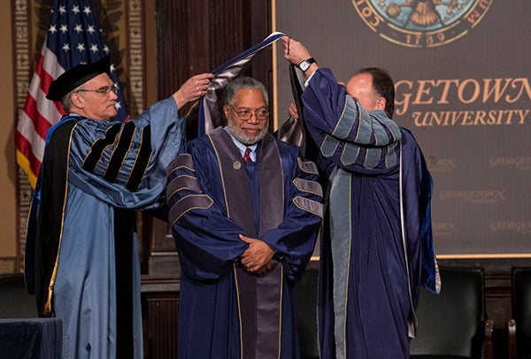 Provost Robert Groves and President John J. DeGioia hood Lonnie Bunch for his honorary doctorate