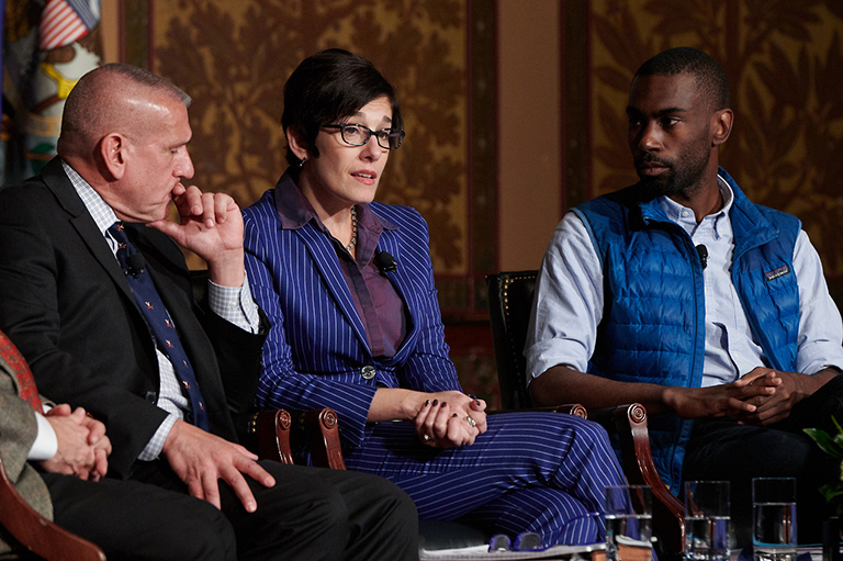 Paula Xinis sits between Timothy Longo and DeRay McKesson on stage in Gaston Hall as they discuss Charlottesville and free speech.