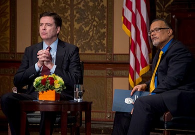 FBI director James Comey and Edward Montgomery, dean of Georgetown's McCourt School of Public Policy, listen as a student asks the FBI leader a question in Gaston Hall.