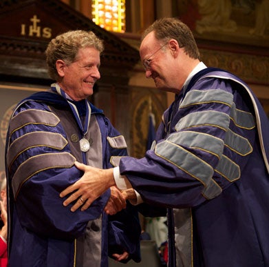 Richard Schlegel shakes hands with John J. DeGioia