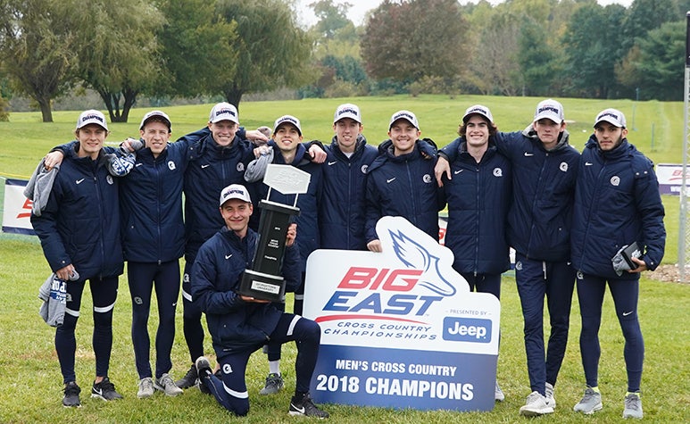 The men's cross country team poses together with their BIG EAST championship trophy. 