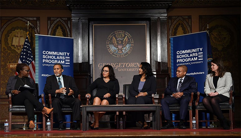 Charlene Brown-Mckenzie listens as James Chesley speaks on a panel with Gloria Bowles-Johnson Laurel Iron Cloud, Joseph Almeida and Bonnie Duncan on stage in Gaston Hall.