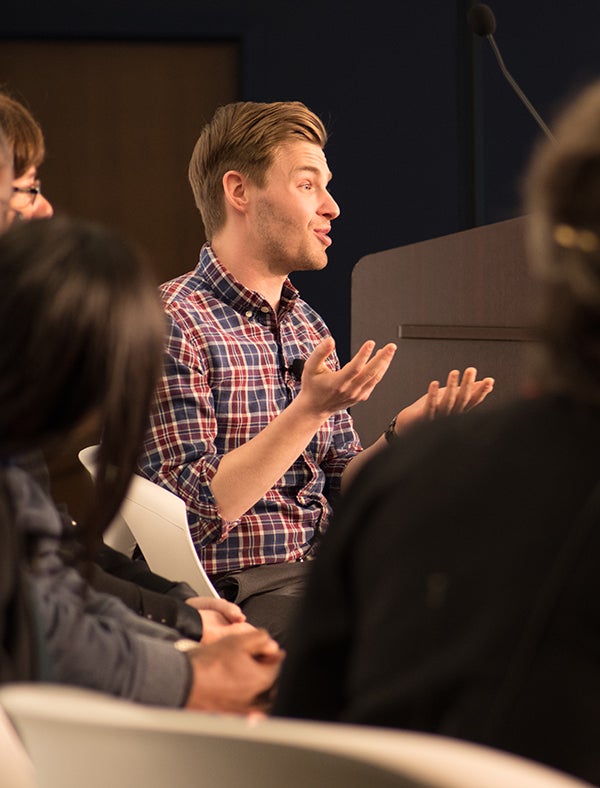 Andrew Walker talks to members of the audience while on stage for a panel discussion.