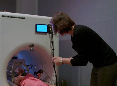 A girl acclimates to the MRI environment while a woman looks on. 