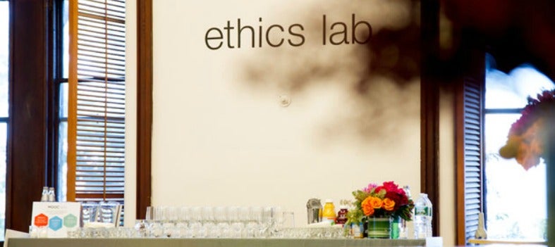 A table with refreshments sits in front of the Ethics Lab logo