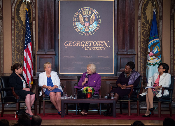 Melanne Verveer listens to panelists during a discussion onstage in Gaston Hall.