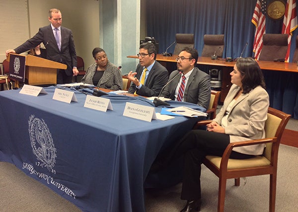 Standing, Chris Murphy, vice president for government relations and community engagement at Georgetown, listens as Abel Núñez, seated second from left, discusses the difficulties undocumented immigrants face in obtaining drivers’ licenses.