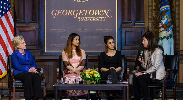 Hillary Rodham Clinton listens, seated, along with Wai Wai Nu and Nadia Murad as Lyse Doucet speaks during their panel discussion.