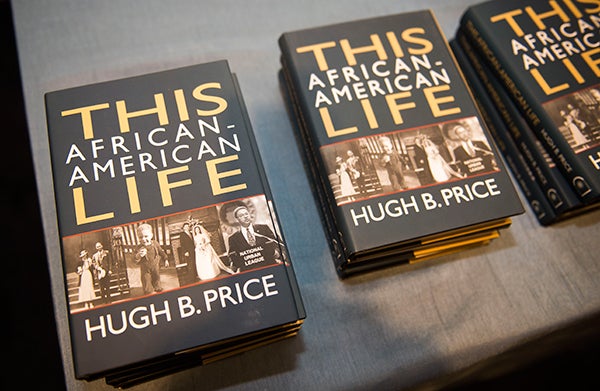 Several copies of the book, This African American Life, sit on a table.