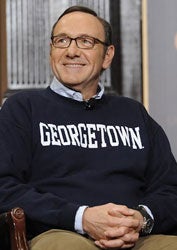 Kevin Spacey smiles while receiving applause for donning a Georgetown shirt during his discussion about ethics, power and politics in Gaston Hall.