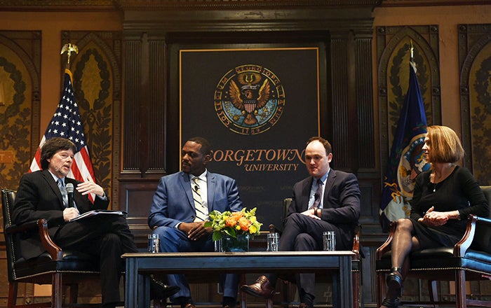 Ken Burns, Jule Hall, Max Kenner and Lynn Novick on stage with American flag and Georgetown University sign