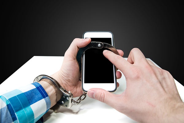 one hand handcuffed to a smartphone with free handing tapping on screen