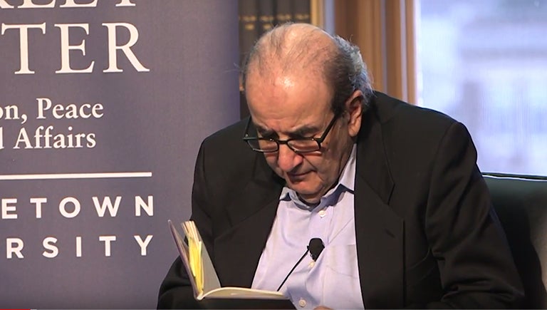 Lawrence Joseph reads from his book while seated during an event in Riggs Library.