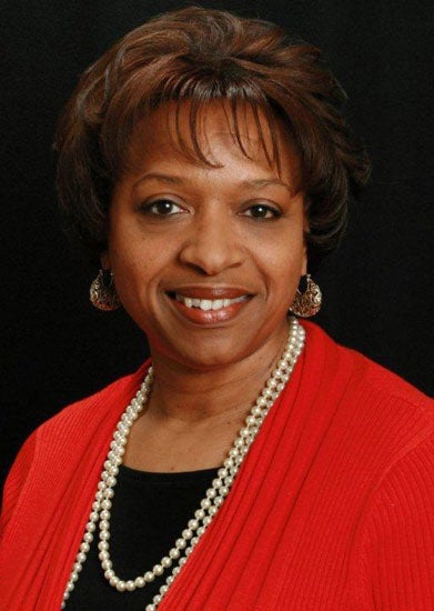 Brenda R. Malone smiles for the camera against a black background. 