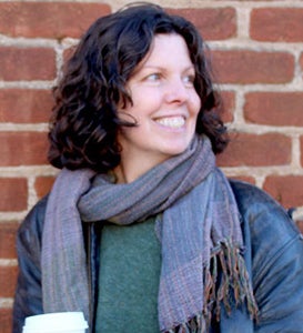 Mary Esselman standing in front of red brick wall