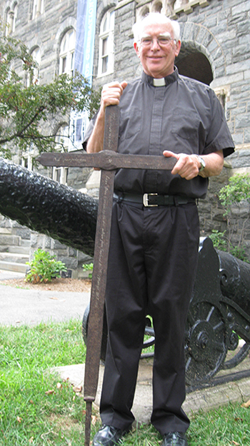 G. Ronald Murphy, S.J., stands with iron cross