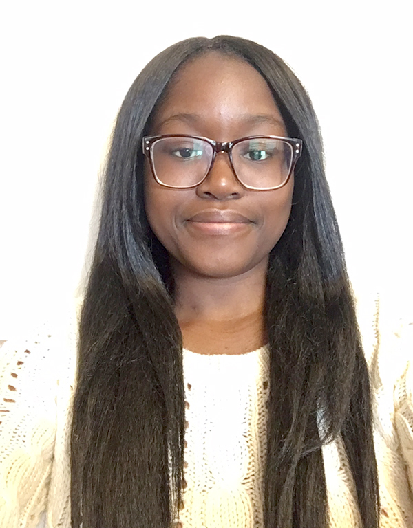 Omoyele Okunola smiles wearing glasses and a cream sweater in a headshot photo with a white background.