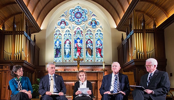 Helen Alvare, Tony Lauinger, Sister Mary Louise Wessell, and Rep. Brad Wenstrup (Ohio-R) sit as a panel in Dahlgren Chapel with stained glass in the background. 