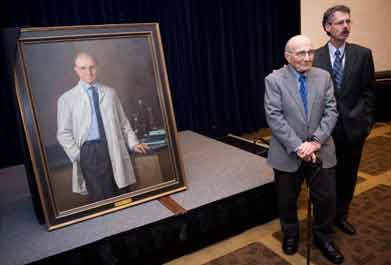 Dr. Edmund Pellegrino and Dr. Howard Federoff, executive vice president for health sciences and executive dean for the School of Medicine at Georgetown, stand in front of a portrait of the bioethics pioneer.