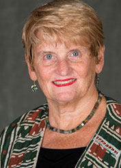Patricia O'Connor smiles against a gray background.