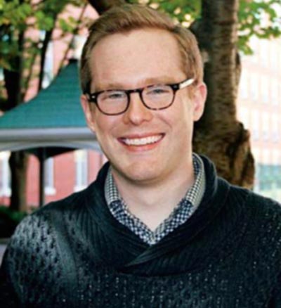 Peter Prindiville, wearing glasses, smiled for a headshot. 