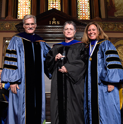 Provost Robert Groves and Professor Janet Mann present Joanne Rappaport with an award for research achievement.