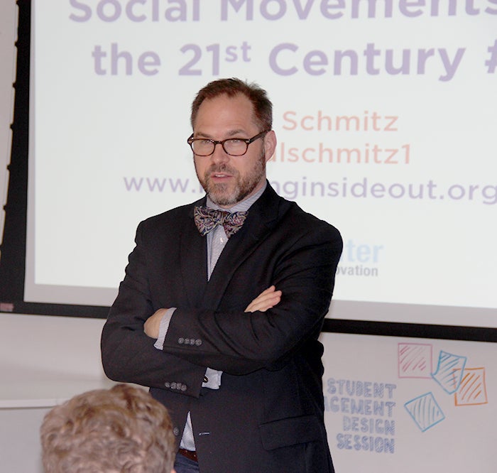 Paul Schmitz, dressed in a bow tie, address an audience during a Social Movements in the 21st Century session.