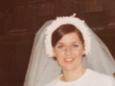 Elizabeth Velez smiling in her wedding dress and veil, circa 1969
