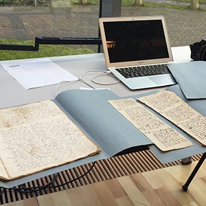 desk with computer and archival documents