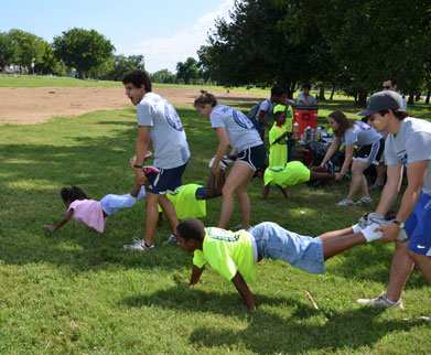 Georgetown students and campers in a wheelbarrow race in a park