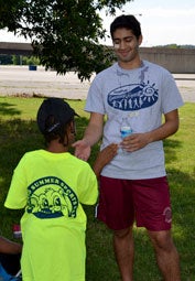 Georgetown student high-fives a camper in a park