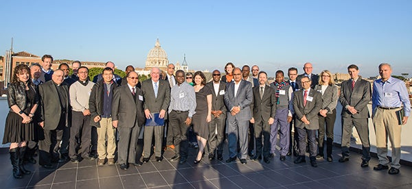 workshop participants pose with the Vatican City skyline in the background