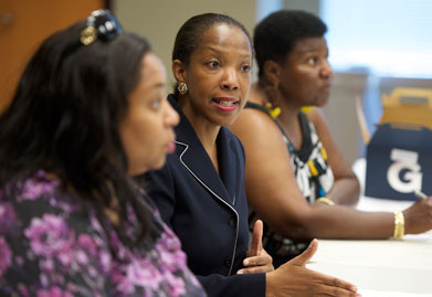 Sherrie Wallington speaks at a table with two other women