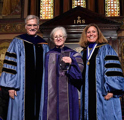 Provost Robert Groves and Janet Mann present Maxine Weinstein with an award for research achievement.