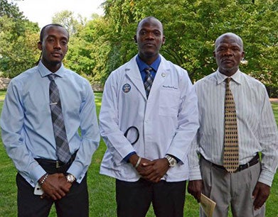 Henry Claude Francois (M'18) stand with his brother, left, and his father, right.