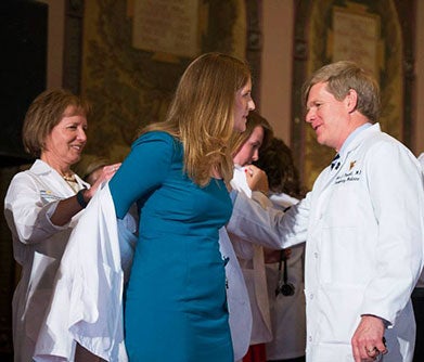 Amy Prescott is "coated" by her parents, who are wearing their white coats.