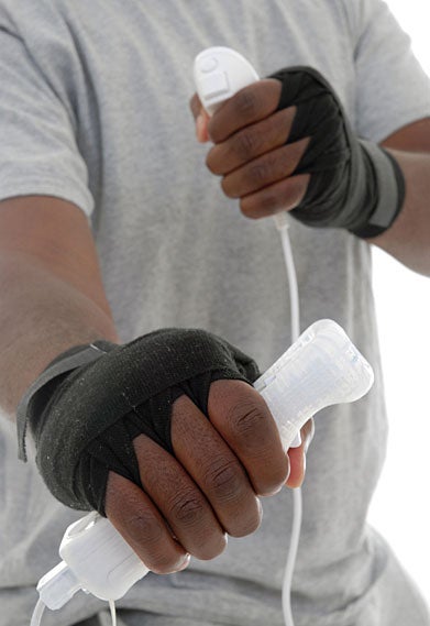 hands grips video game controllers in punching pose