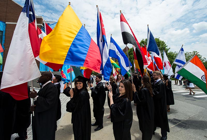 graduating seniors carry flags in processional