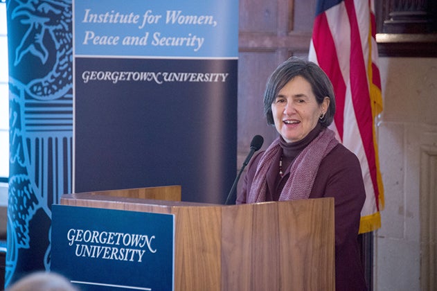 Rula Ghani standing at podium in Gaston Hall with banner reading "Institute for Women, Peace and Security" and the American flag