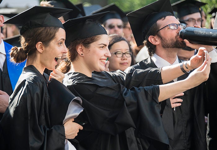 graduates smile and take photos