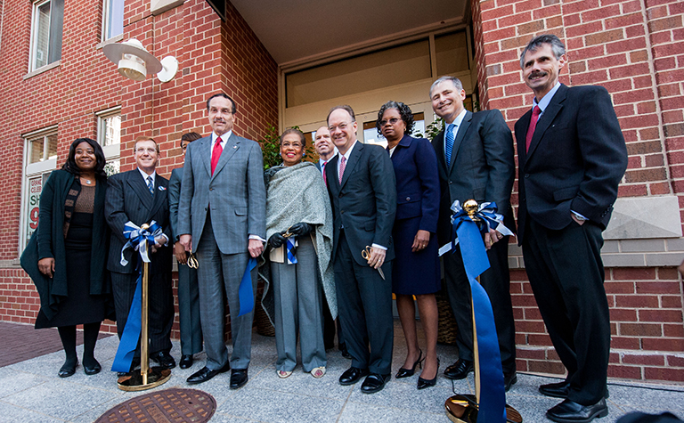 Georgetown University and City Officials cut a blue and gray ribbon to open the new office space