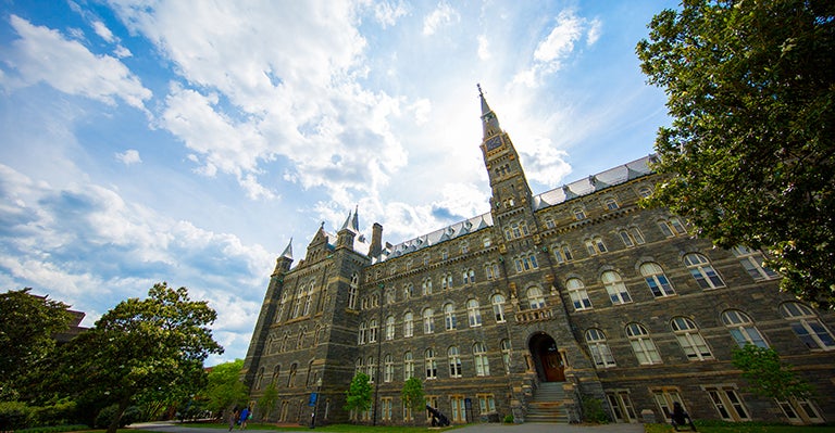 An artistic, broad, slanted view of Healy Hall with a blue sky and crisp clouds in the background