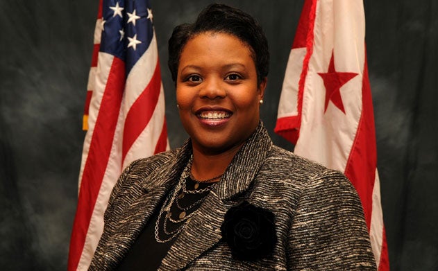 Kaya Henderson poses in front of the United States flag and the District of Columbia flag