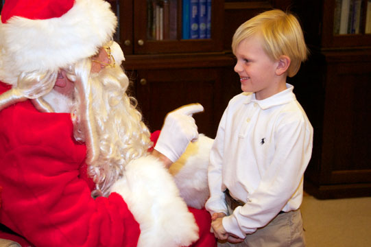 Santa points at a smiling Charlie Wooters, the son of Assistant Vice President of Communications Stacy Kerr.
