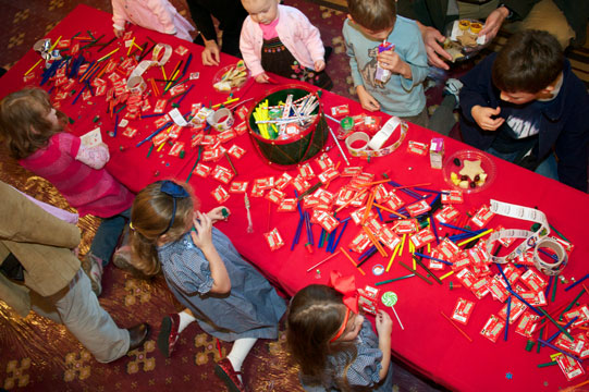 An overhead shot of a red table covered with candies and activities.