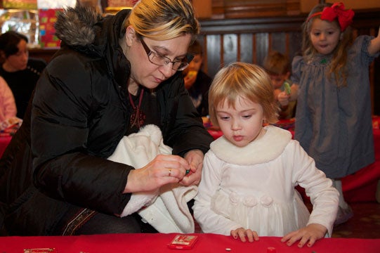 Aleksandra Dakic, who works in the Lombardi Cancer Center, and her daughter, Isidora, check out the candy and toy table.