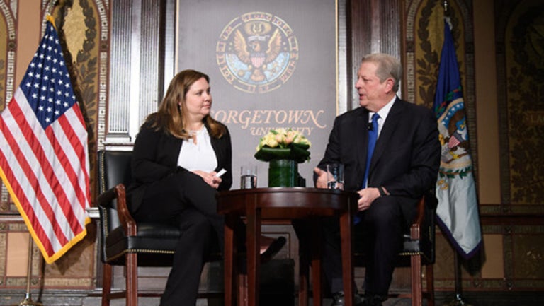 Joanna Lewis sitting on stage with Al Gore